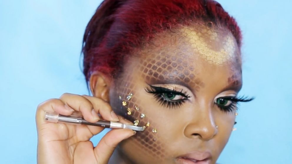 PHOTO: Makeup artist and YouTuber Queenii Rozenblad gets creative with her mermaid makeup look by using a fish net wig cap over he face to create scales.