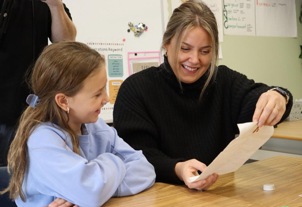 PHOTO: Makenzie Van Eyk reads from the letter she wrote back in 1998 as her daughter Scarlet looks on.