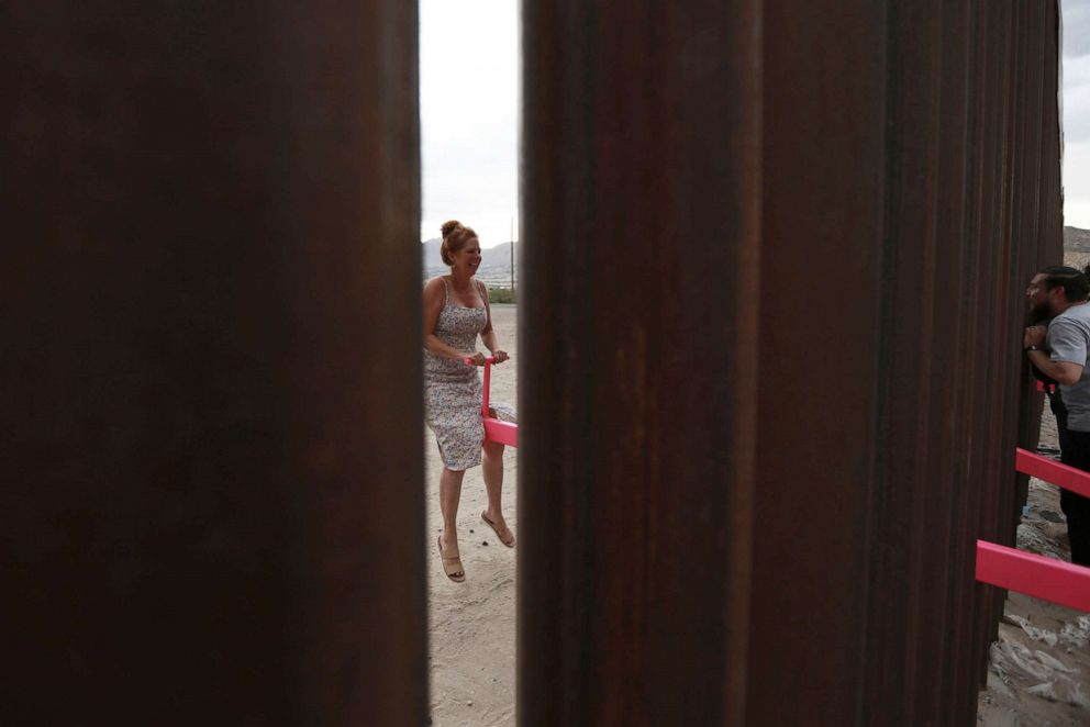 PHOTO: An American woman plays on a seesaw installed between the border fence that divides Mexico from the United States in Ciudad de Juarez, Mexico, July 28, 2019.