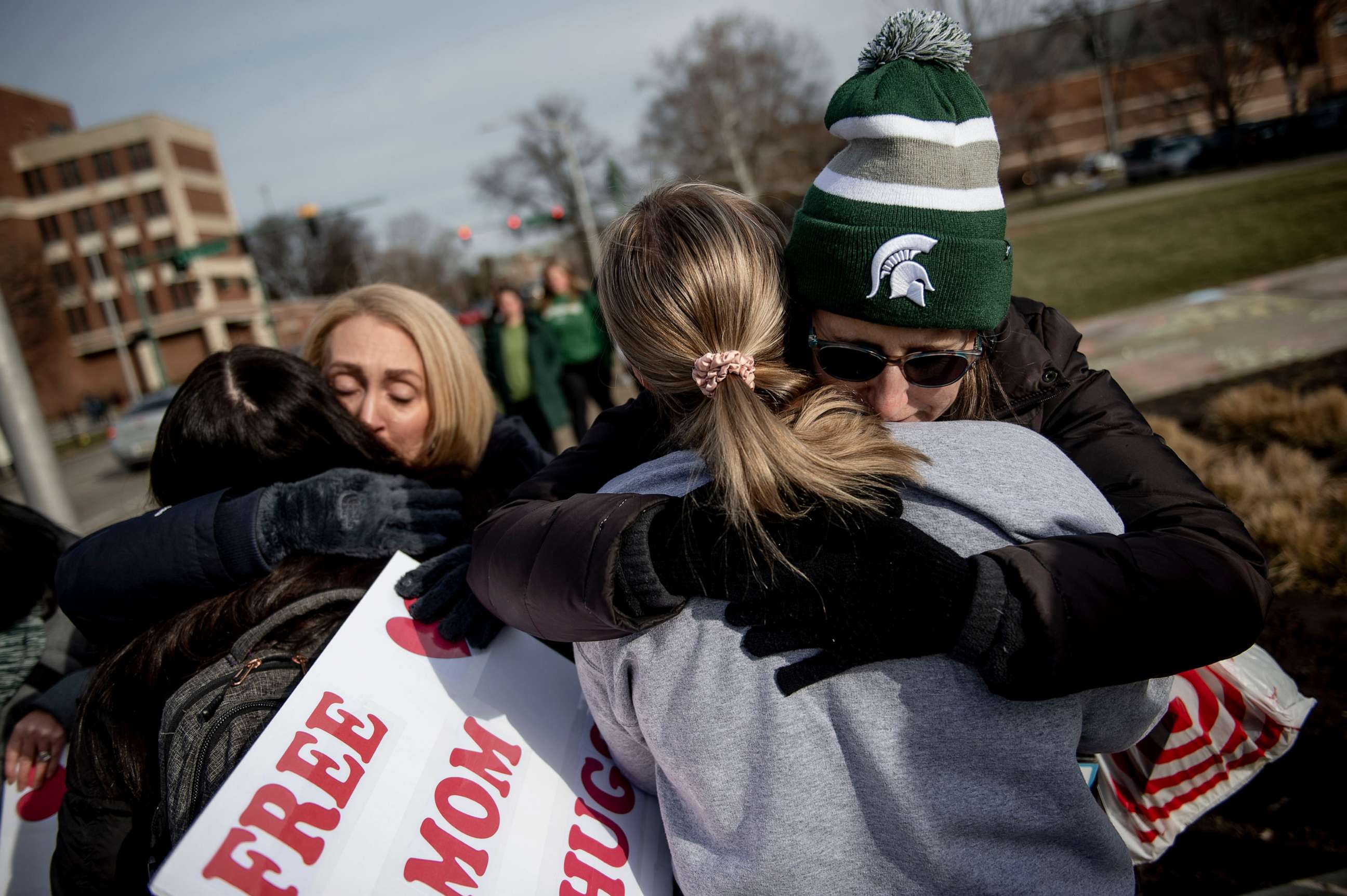 PHOTO: Sue Dodde, a mother from Conklin at right, embraces a student with a "free hug from a mom" as campus opens back up for the first day of classes, Feb. 20, 2023, at Michigan State University in East Lansing, Mich.