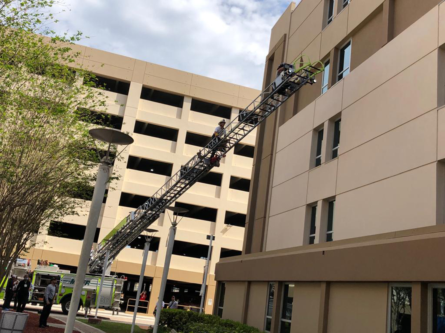 PHOTO: Firefighters climb the ladder from the fire truck to visit with their colleague through the fourth floor window of a hospital in Miami-Dade County, Fla., April 3, 2020.