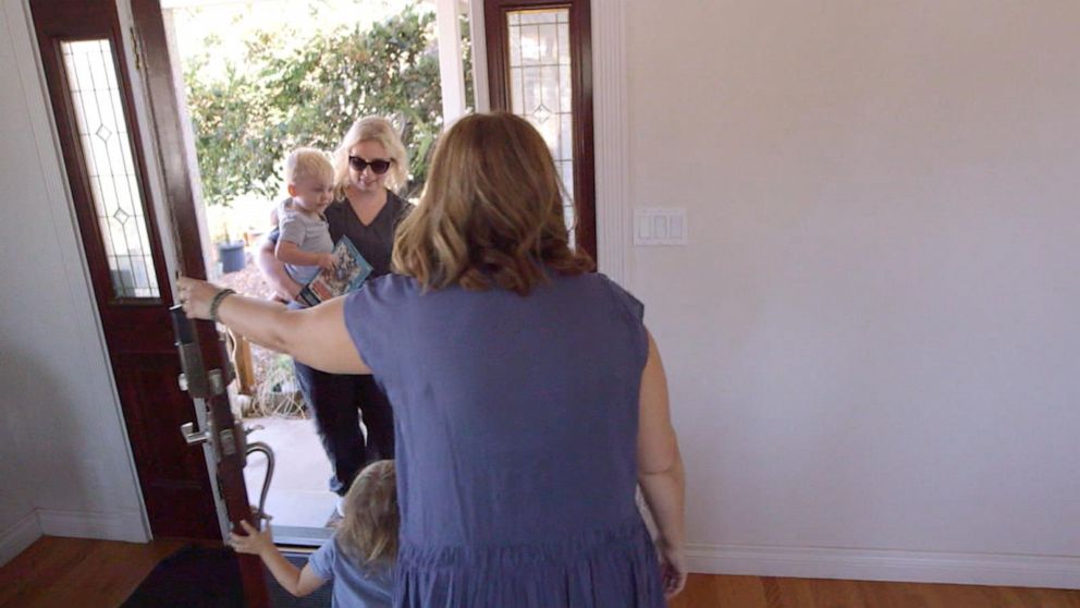 PHOTO: Michelle Espinoza welcomes Whitney Bogan and her son into her home for a day of child care.