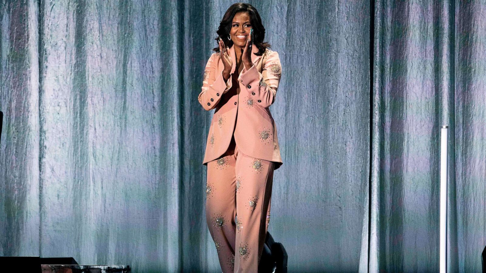 PHOTO: Former first lady Michelle Obama waves on stage of the Royal Arena in Copenhagen, April 9, 2019, during a tour to promote her memoir, "Becoming".