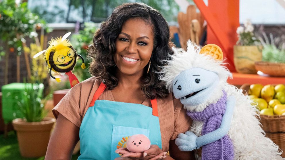 PHOTO: Former first lady Michelle Obama appears with Busy, a bee puppet, left, Mochi, a pink round puppet, and Waffles, a furry puppet with waffle ears on the set of the children's series "Waffles + Mochi."
