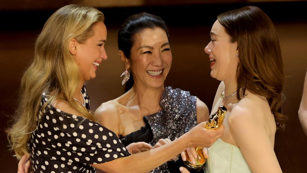 PHOTO: Emma Stone, right, accepts the Best Actress in a Leading Role award for "Poor Things" from Jennifer Lawrence, left, and Michelle Yeoh onstage during the 96th Annual Academy Awards, March 10, 2024, in Hollywood, Calif.