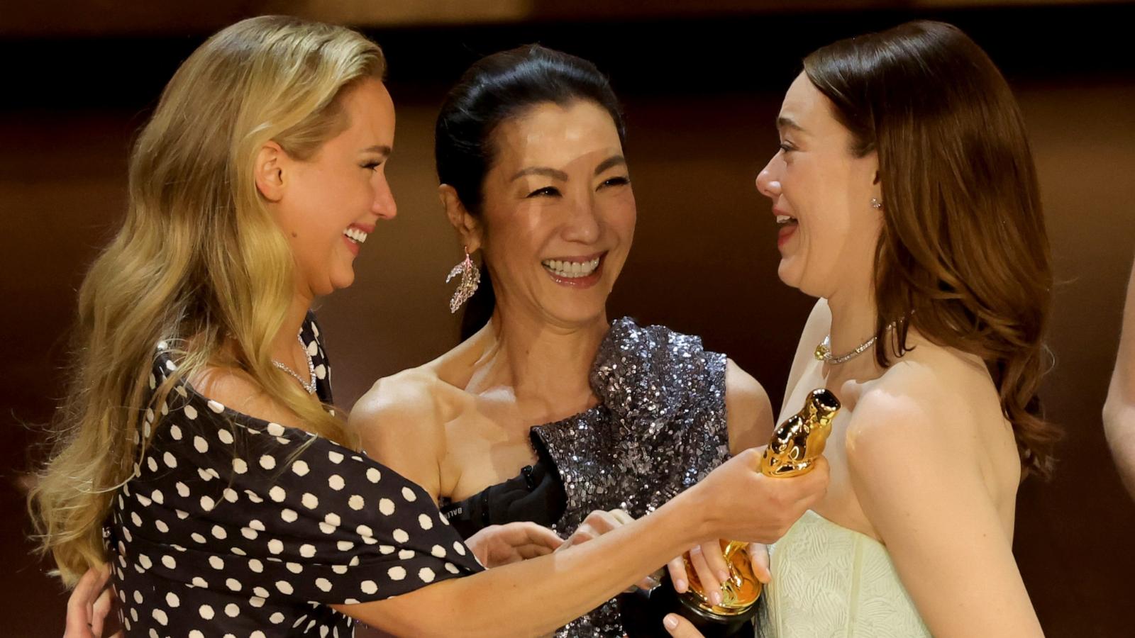 PHOTO: Emma Stone, right, accepts the Best Actress in a Leading Role award for "Poor Things" from Jennifer Lawrence, left, and Michelle Yeoh onstage during the 96th Annual Academy Awards, March 10, 2024, in Hollywood, Calif.