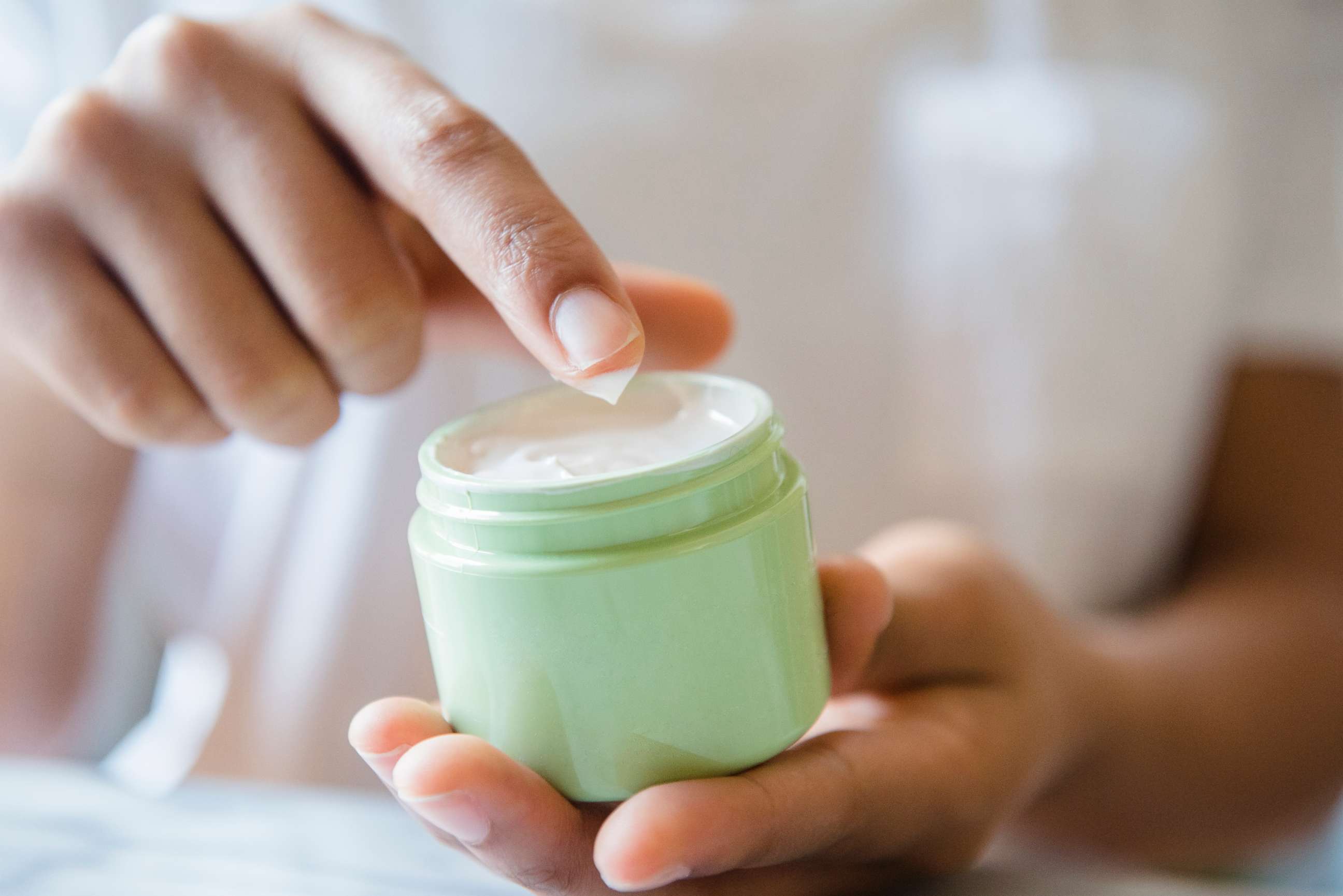 PHOTO: A woman applying moisturizer. 