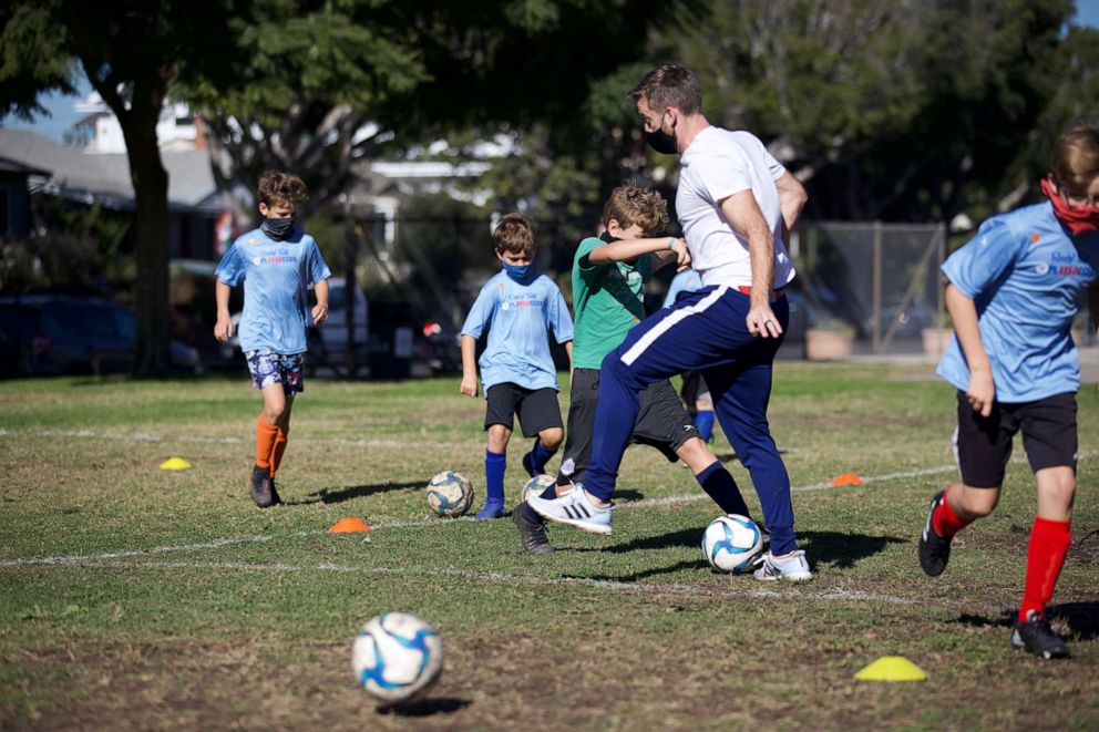PHOTO: A coach runs through drills with a youth soccer team.