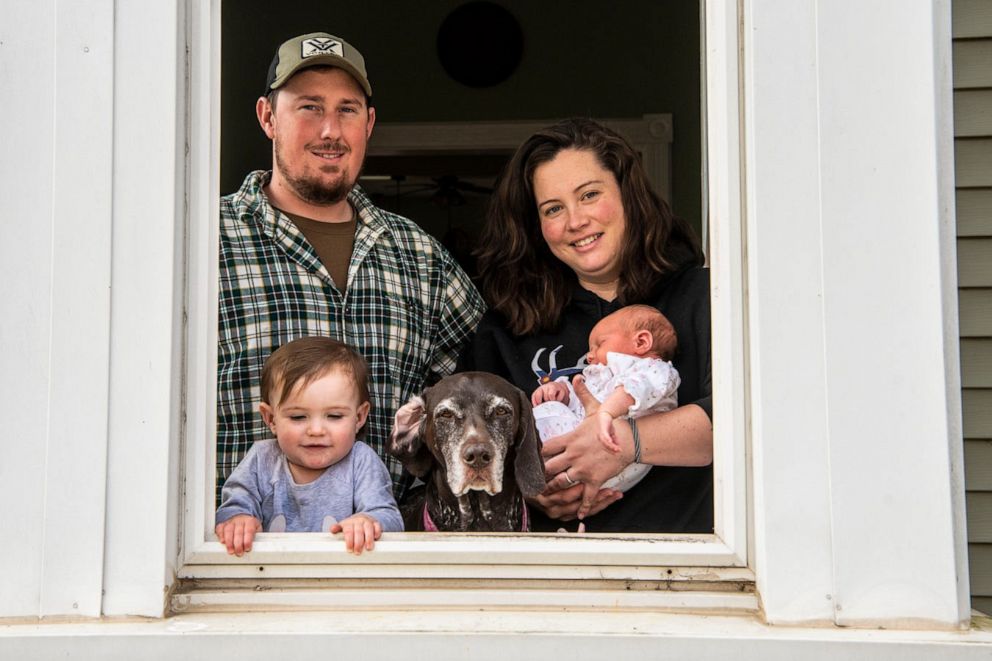 PHOTO: Mitchell and Mallory Pease pose for a portrait with their daughters Emma Jean Pease, 2, and newborn Alivia Pease on Tuesday, April 7, 2020, at their home in Homer, Mich.