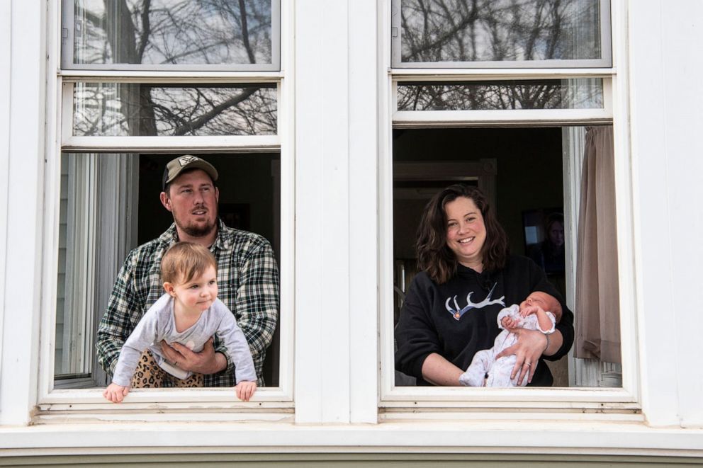 PHOTO: Mitchell and Mallory Pease pose for a portrait with their daughters Emma Jean Pease, 2, and newborn Alivia Pease on Tuesday, April 7, 2020, at their home in Homer, Mich.