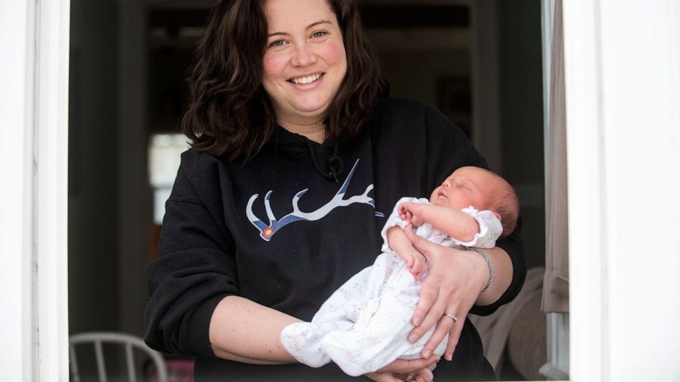 PHOTO: Mallory Pease holds her newborn daughter Alivia after recovering from COVID-19 on April 7, 2020, at their home in Homer, Mich.