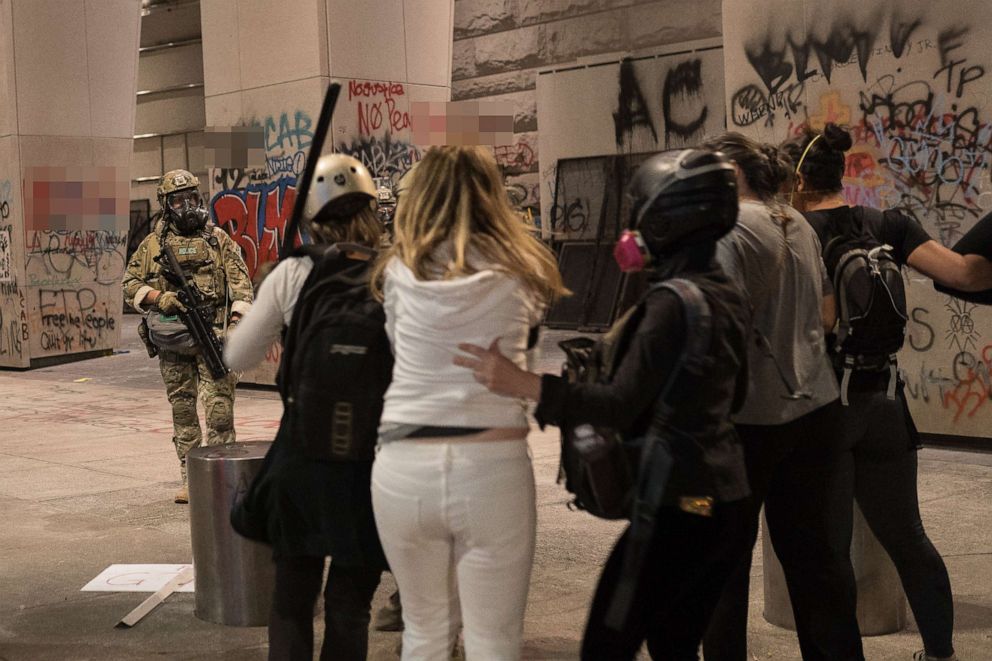 PHOTO: Moms form a human shield as CBP agents prepare to fire tear gas and flash bangs at the Federal Courthouse in Portland, Oregon, July 19, 2020, during another night of protests in the city.