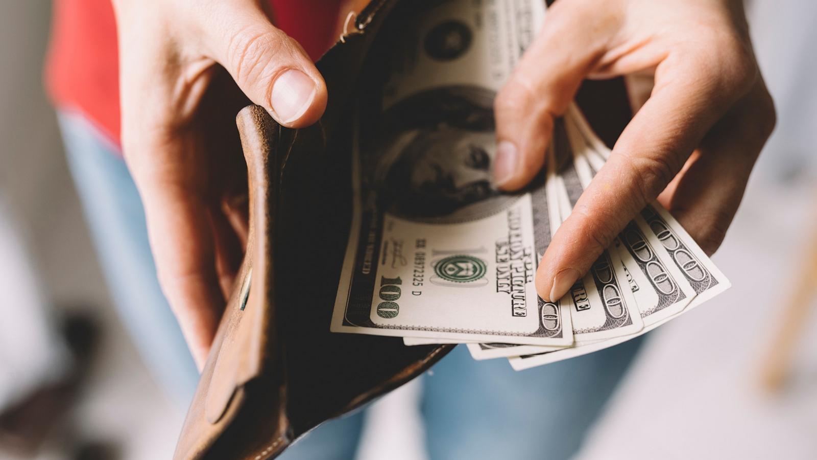 PHOTO: Stock photo of a person taking cash out of a wallet.