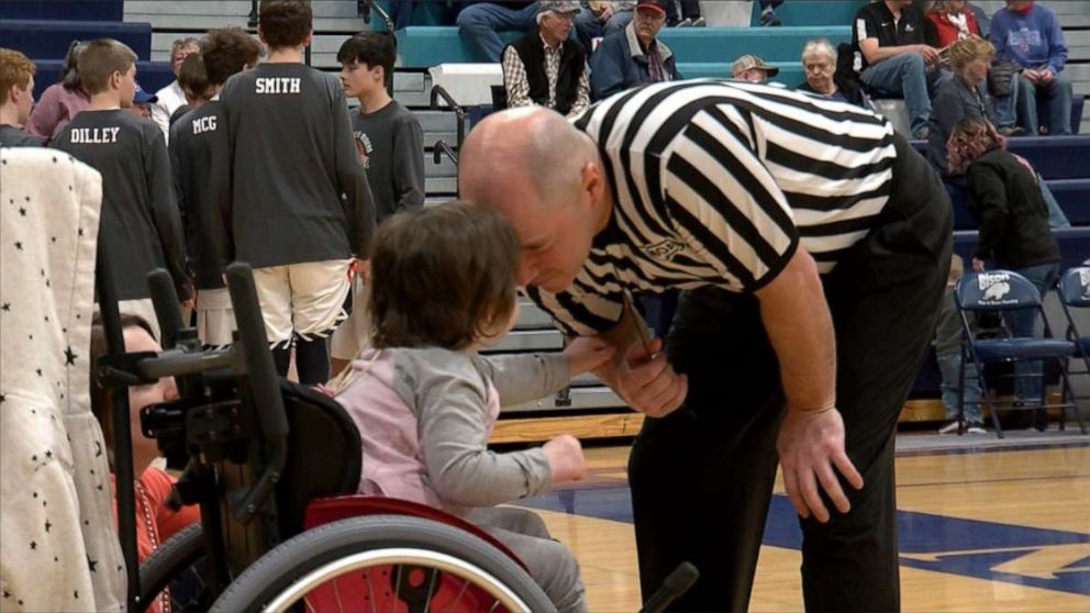 PHOTO: Finnley Foster watches her dad Pat Foster referee a high school basketball game in Great Falls, Montana, on Feb. 21, 2020.