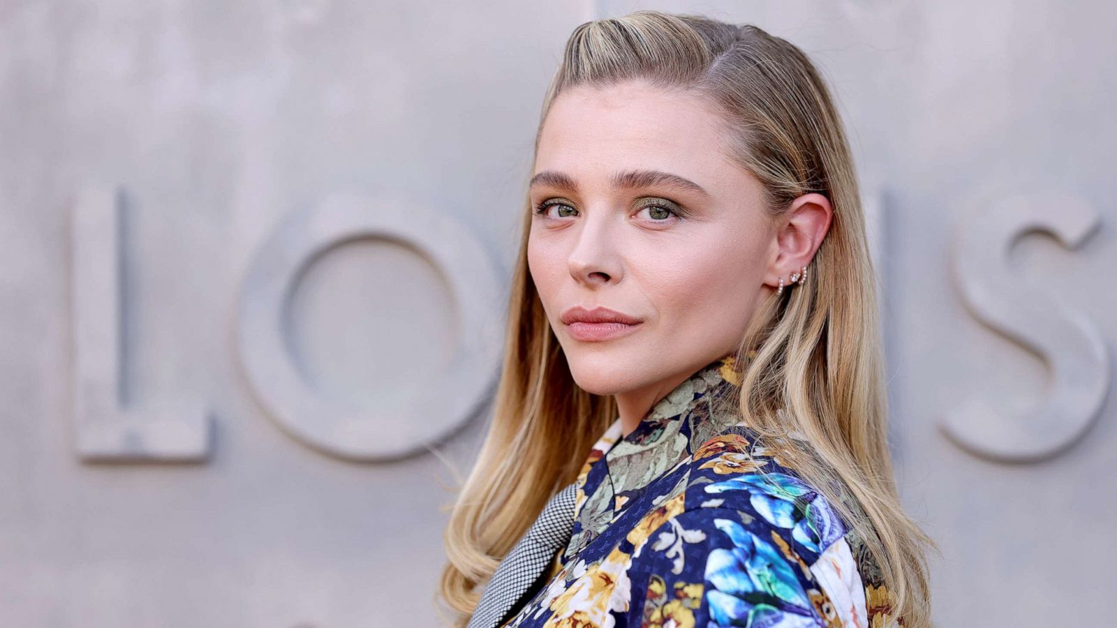 The kid behind Chloe Grace Moretz looks like a man in his 30's : r