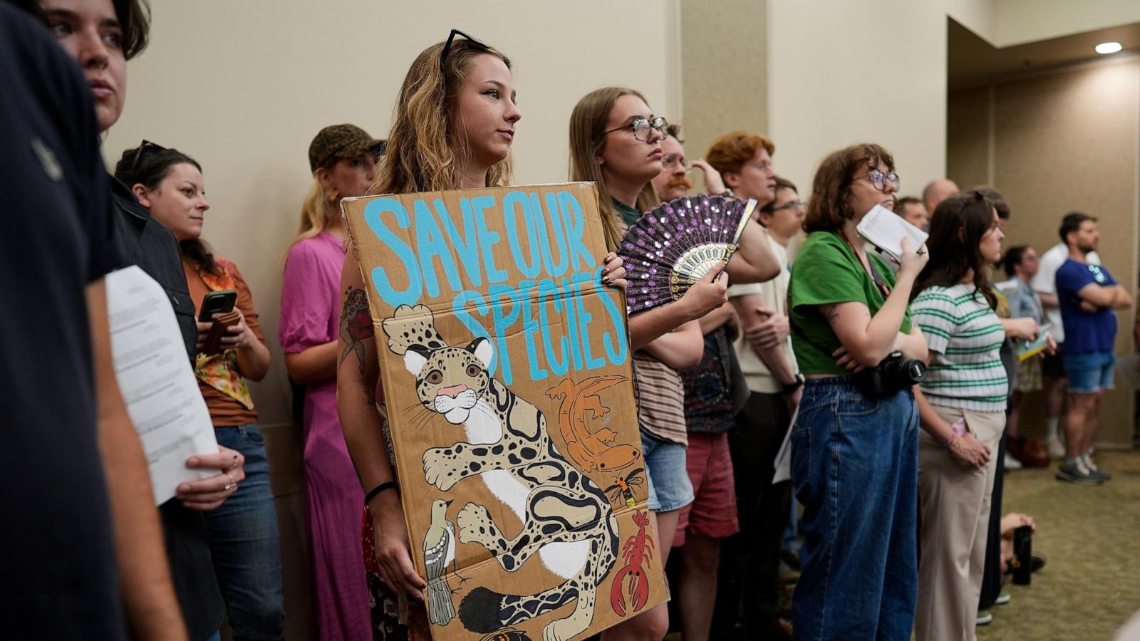 PHOTO: Karina Manley holds a sign against a proposed data center adjacent to the Nashville Zoo during a planning commission meeting, June 11, 2026, in Nashville, Tenn.