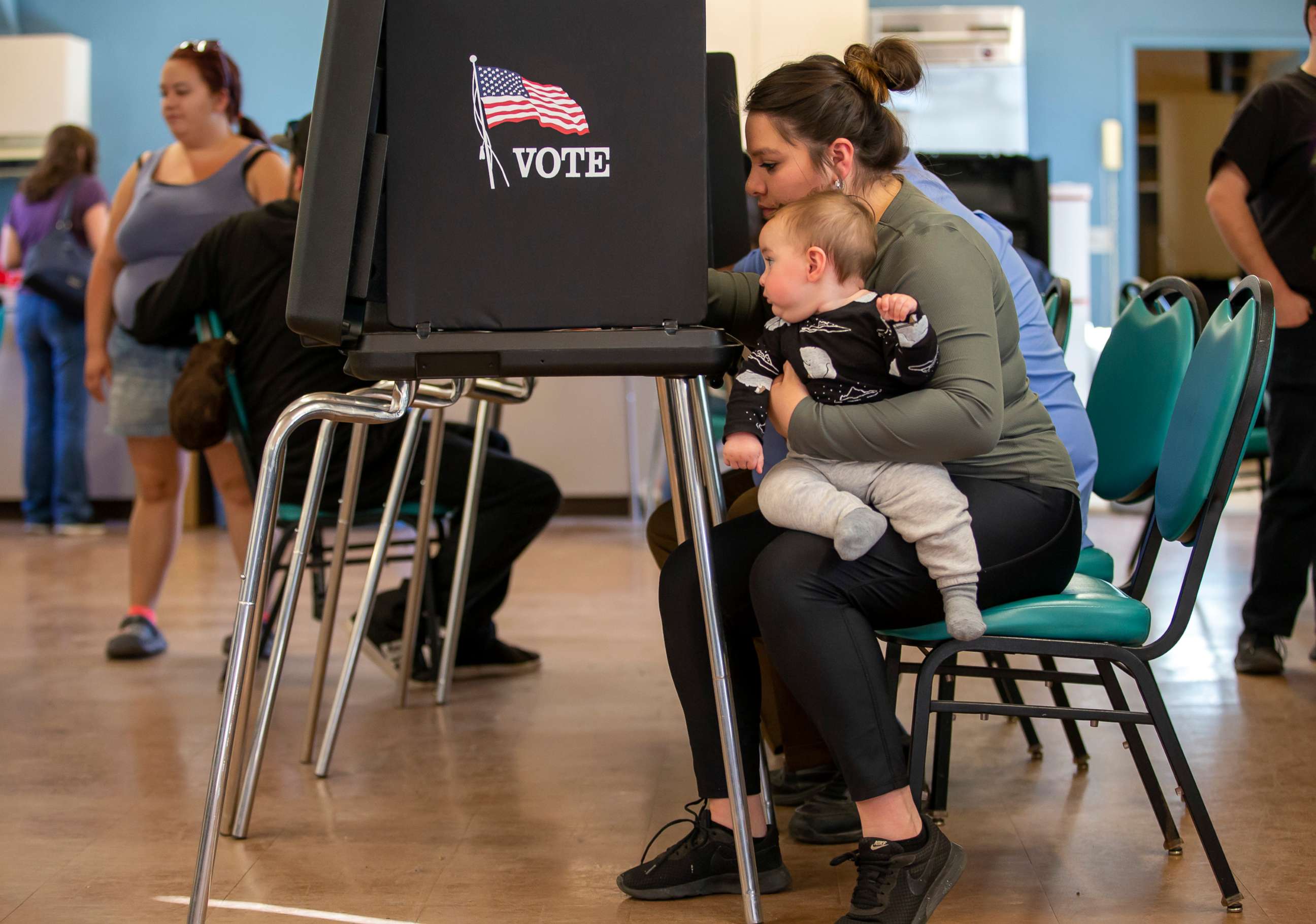 PHOTO: Miranda Padilla holds her 11-month-old son Grayson Sanchez while marking her ballot at a polling center, Nov. 8, 2022, Albuquerque, N.M.