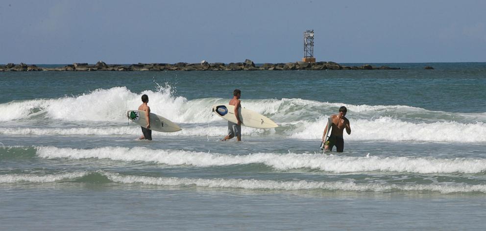 PHOTO: Surfers hit the waves at New Smyrna Beach in Florida. 