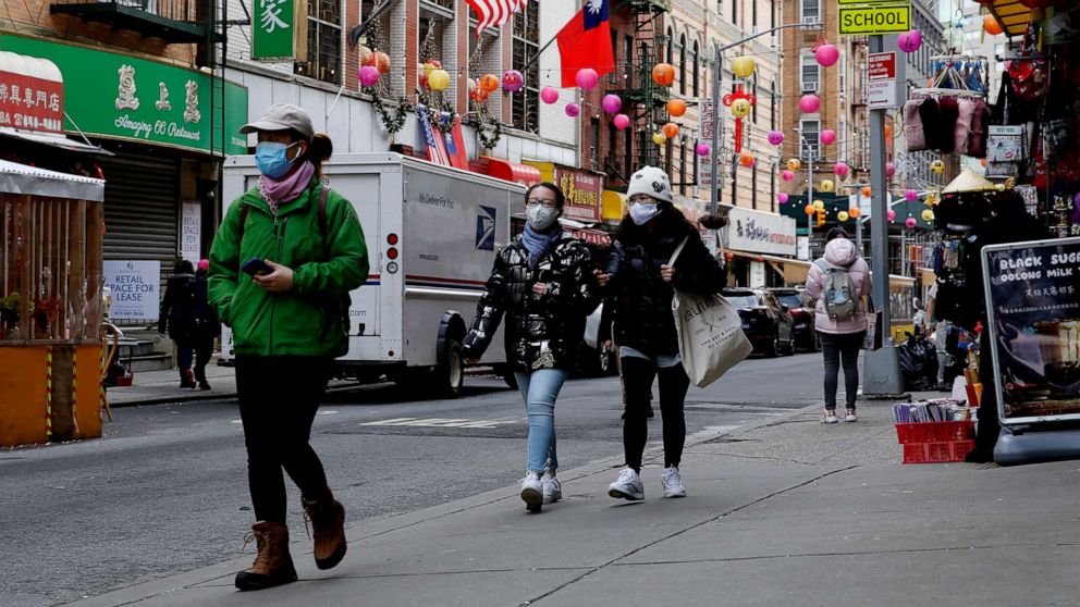 PHOTO: People walk through the streets of Chinatown on March 01, 2021, in New York.