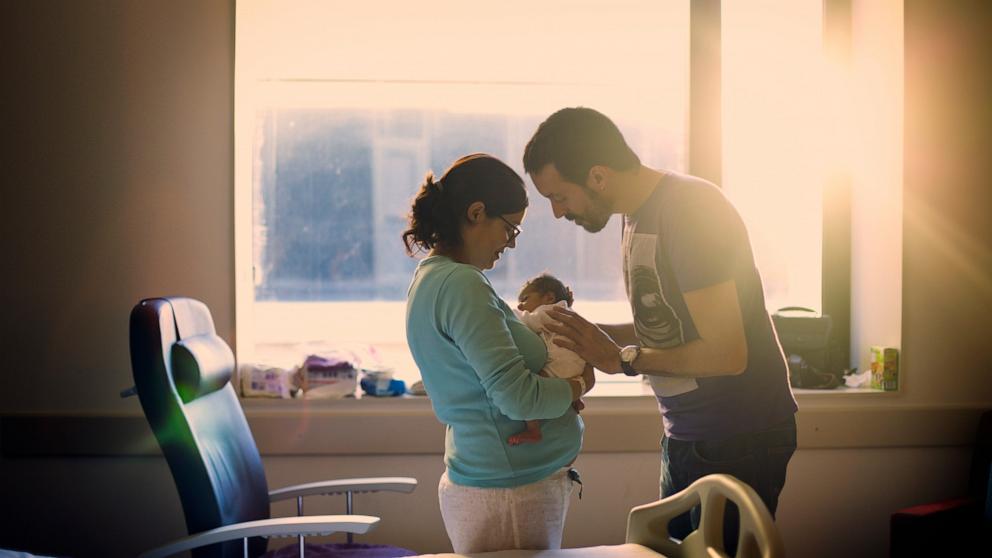 PHOTO: Stock photo of parents with their newborn.