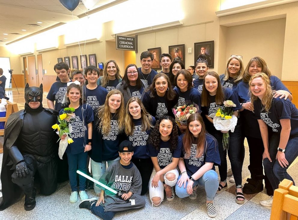 PHOTO: Nike Schwartz, 8, center, poses with a Batman character and family and friends on his adoption day, Feb. 17, 2020.