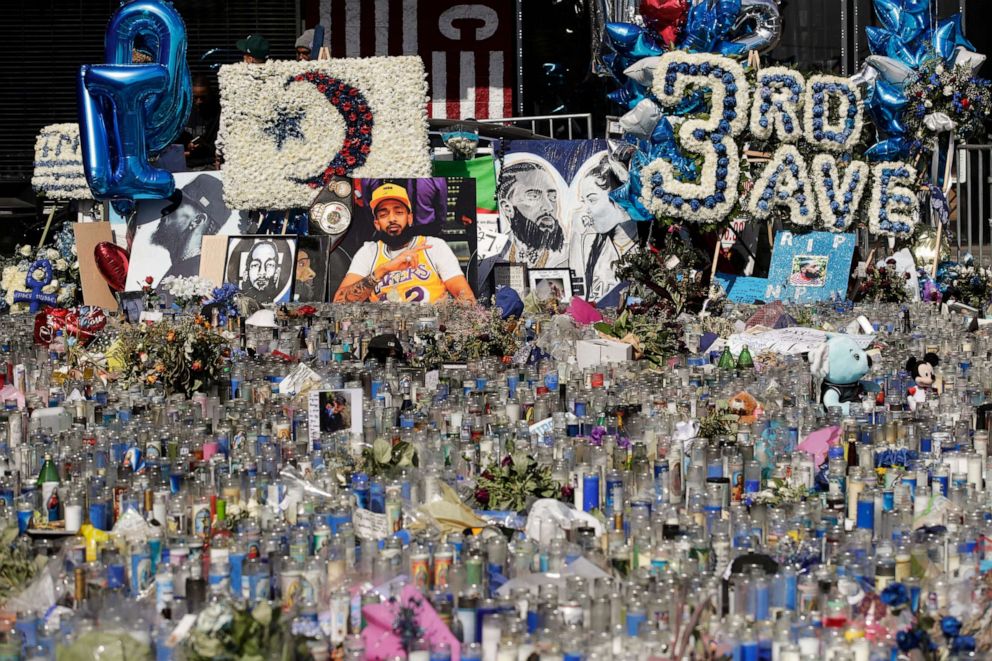 PHOTO: A makeshift memorial site for slain rapper Nipsey Hussle is filled with candles outside The Marathon Clothing store in Los Angeles, April 11, 2019