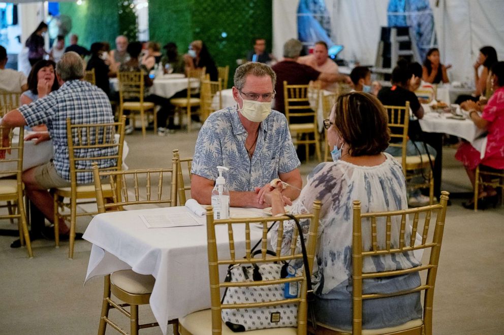 PHOTO: Customers wearing protective face masks dine at King Umberto Restaurant in Elmont, New York, Aug. 05, 2020.