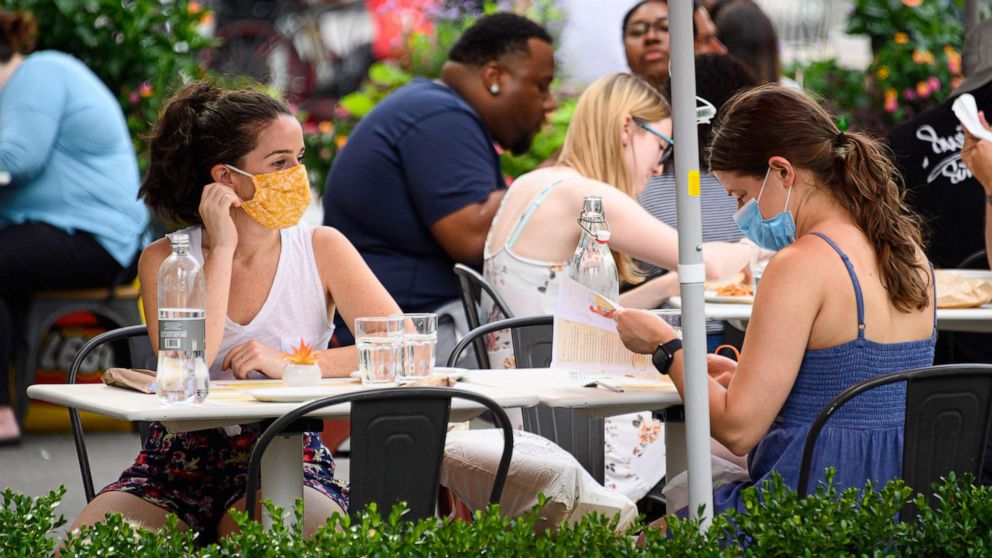 PHOTO: People wear protective face masks at an outdoor restaurant in the Flatiron District of New York, July 26, 2020.