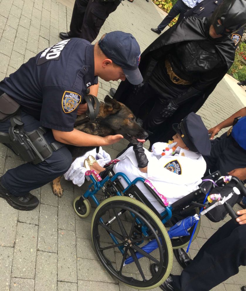 PHOTO: 9-year-old Aniya Ardon sits on her mother's lap as she greets an NYPD police officer at NewYork-Presbyterian Morgan Stanley Children's Hospital. 