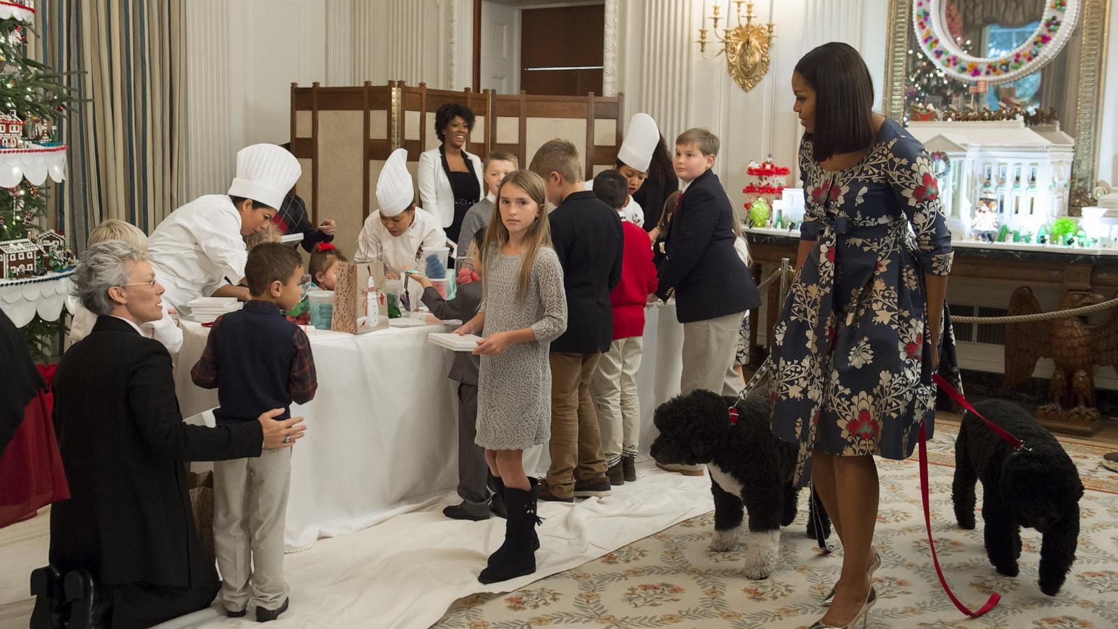 First Lady Michelle Obama, with the First Family's dogs Sunny and Bo, greets children of military families during the unveiling of the 2016 holiday decorations in the theme of "The Gift of the Holidays" on November 29, 2016.