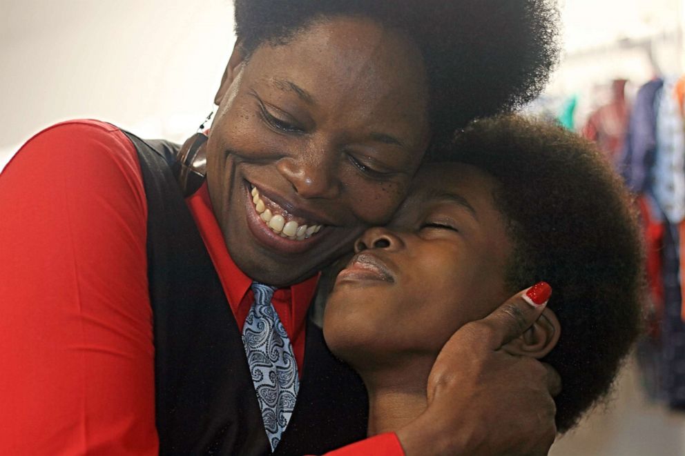 PHOTO: Obocho Peters, an 11-year-old entrepreneur, receives a hug from his mother, Sasha, at his thrift shop located in the Brooklyn borough of New York, Feb. 17, 2020.