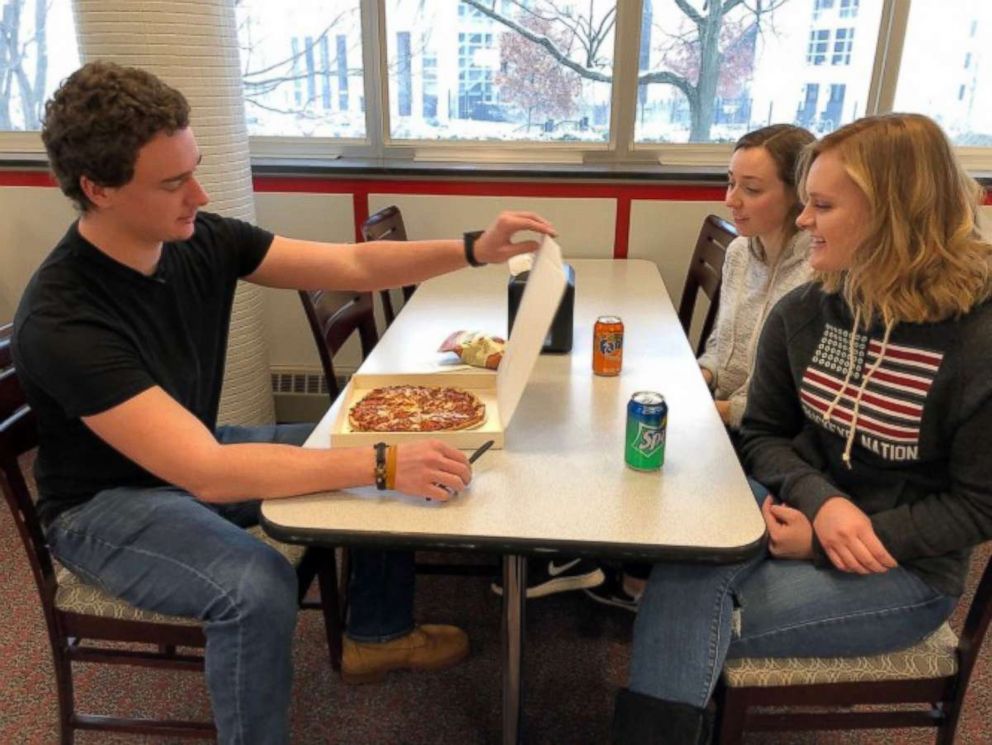 PHOTO: Students enjoy a warm pizza from the pizza ATM.