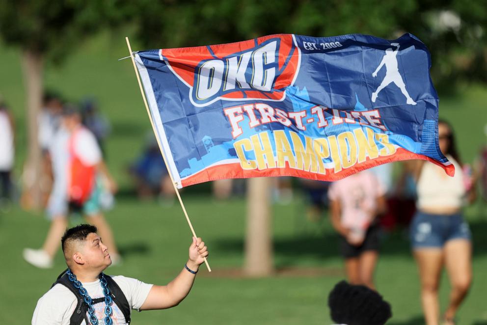 PHOTO: A fan holds a flag before a celebration of the Oklahoma City Thunder's NBA basketball championship, June 24, 2025, in Oklahoma City.