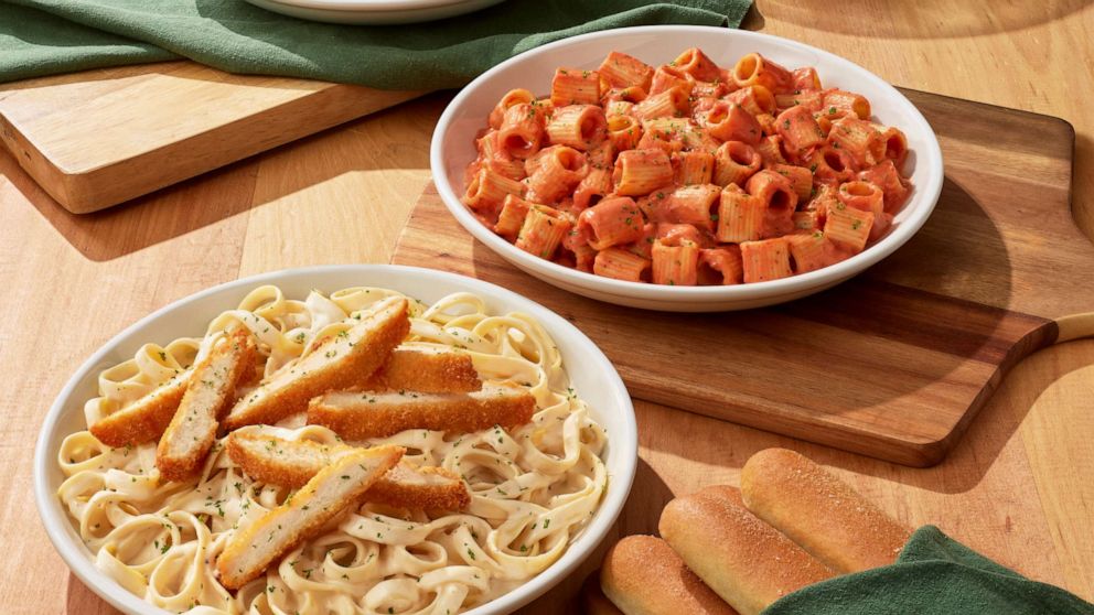 PHOTO: Bowls of pasta at Olive Garden with salad and breadsticks.