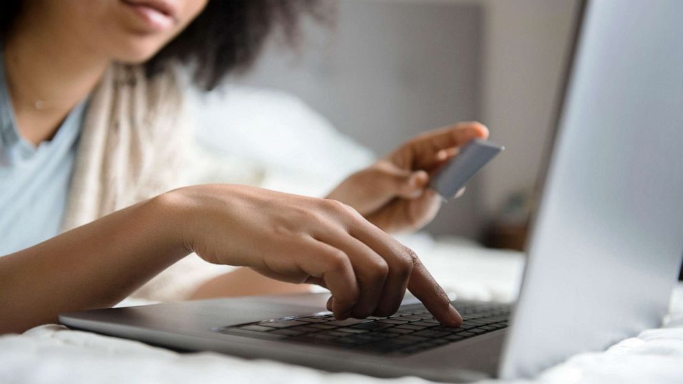 PHOTO: A woman shops online while laying in bed in an undated stock image.