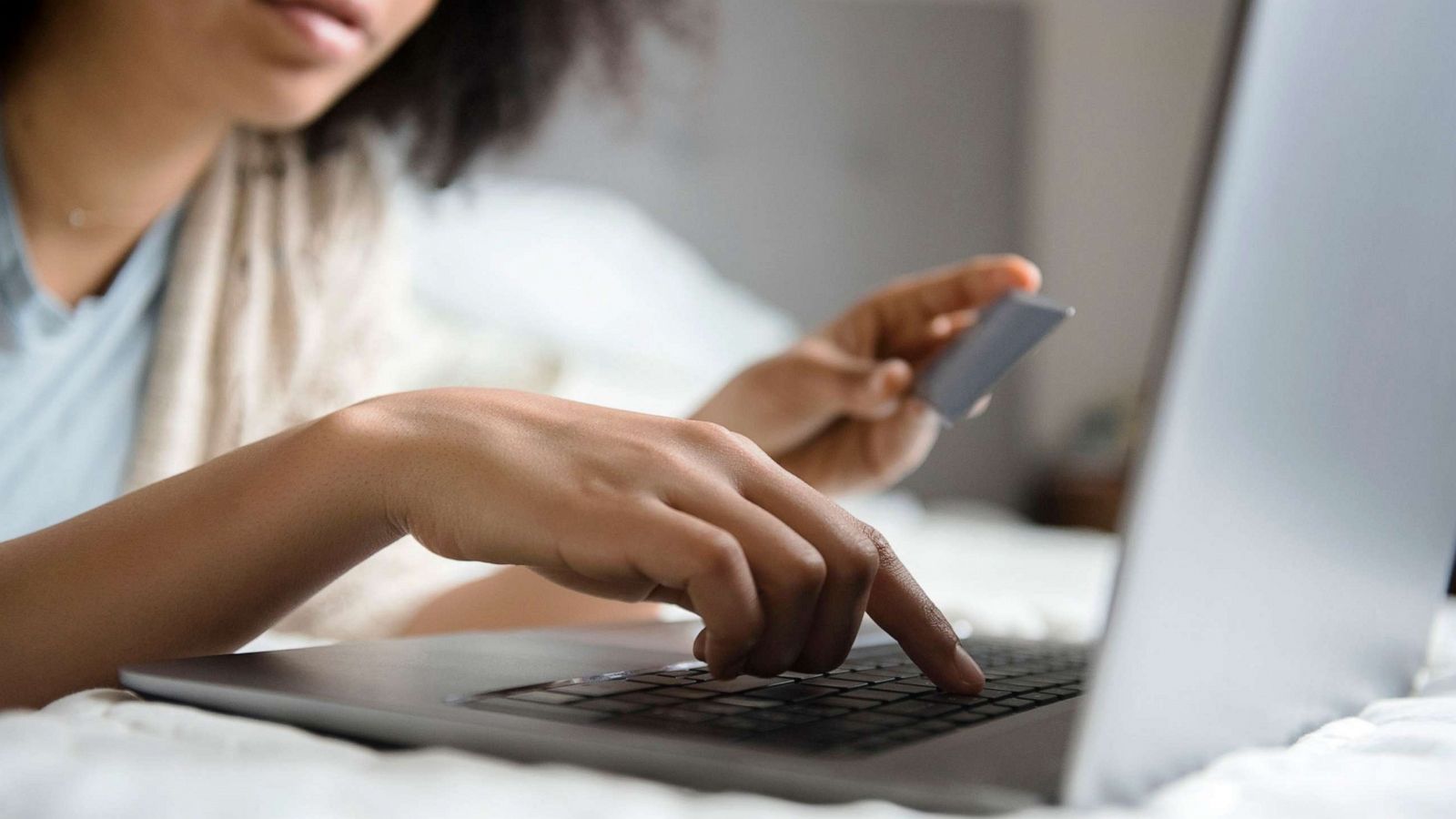 PHOTO: A woman shops online while laying in bed in an undated stock image.