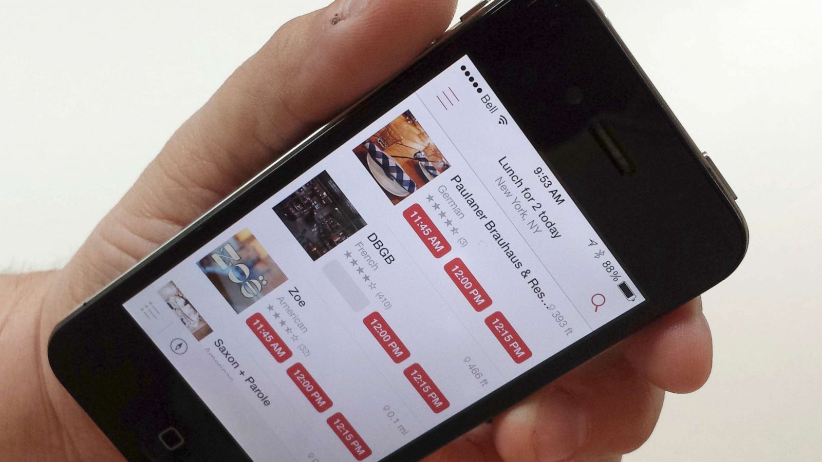 PHOTO: A man holds a smartphone displaying the OpenTable app in a photo illustration in Toronto, June 13, 2014.