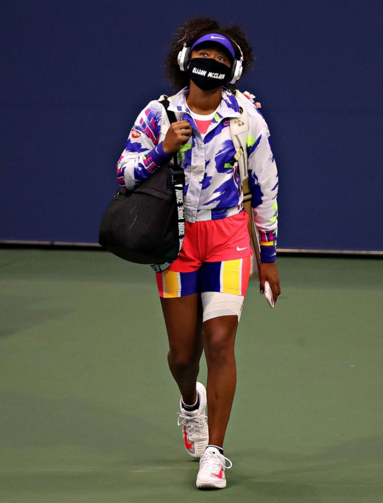 PHOTO: Naomi Osaka walks onto the court wearing a mask bearing Elijah McClain's name before her singles second round match against Camila Giorgi of Italy on Day Three of the US Open, Sept. 2, 2020, in Queens, New York.