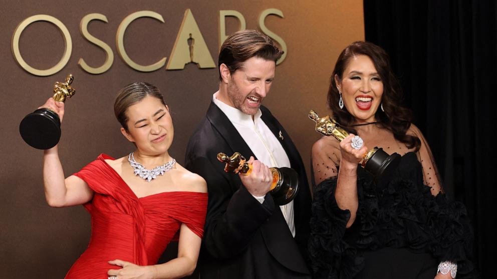 PHOTO: Maggie Kang, Chris Appelhans and Michelle L.M. Wong pose with the Oscar for Best Animated Feature Film for "KPop Demon Hunters" in the Oscars photo room at the 98th Academy Awards in Hollywood, March 15, 2026.   