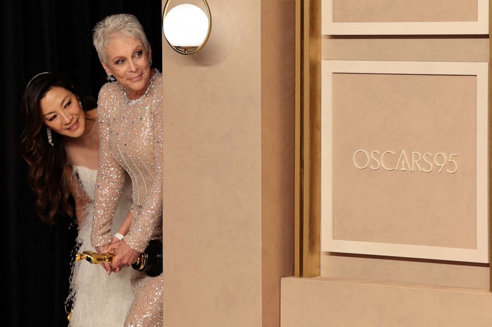 PHOTO: Oscar winners Jamie Lee Curtis and Michelle Yeoh watch backstage as Brendan Fraser poses with his Oscar in the photo room at the 95th Academy Awards in Hollywood, March 12, 2023.