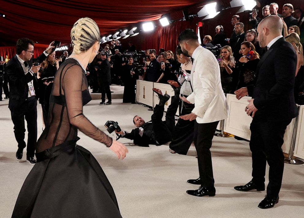 PHOTO: Lady Gaga walks over to help a photographer who fell on the champagne-colored red carpet during the Oscars arrivals at the 95th Academy Awards in Hollywood, Mar. 12, 2023.