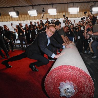 PHOTO: Academy Awards host Conan O'Brien pushes the rolled red carpet during its rollout for the 97th Academy Awards in Los Angeles, Feb. 26, 2025.