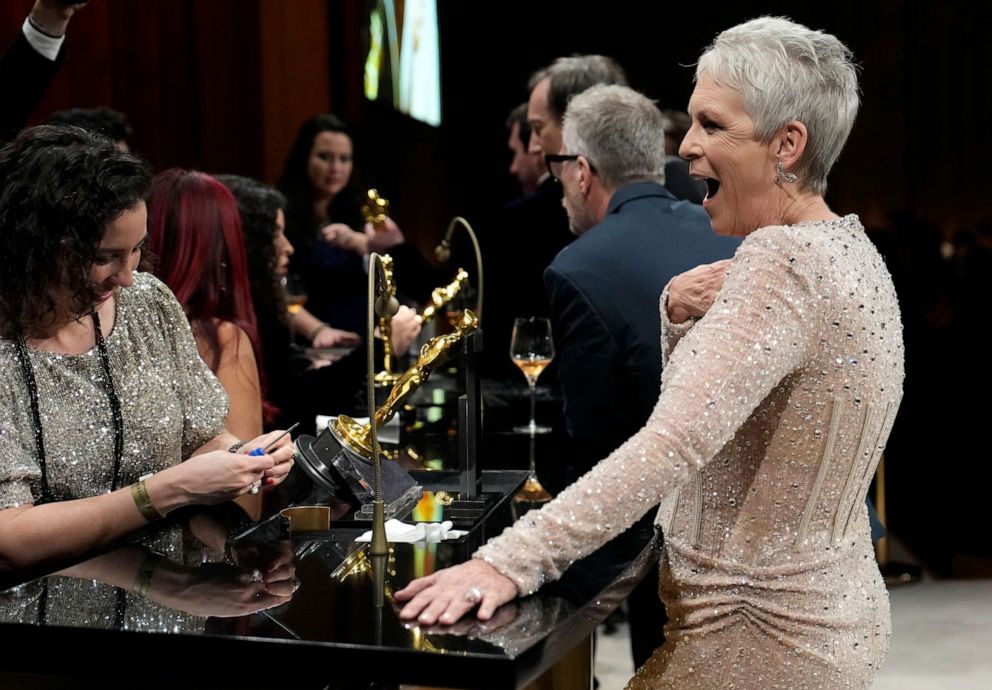 PHOTO: Jamie Lee Curtis, winner of the award for best performance by an actress in a supporting role for "Everything Everywhere All at Once," gets her statuette engraved at the Academy Awards Governors Ball, Mar. 12, 2023, in Hollywood.
