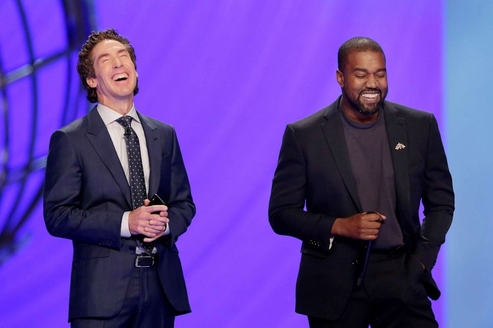 PHOTO: With their eyes closed for prayer, Joel Osteen, left, and Kanye West laugh as West makes a joke while leading the prayer during a service at Lakewood Church, Nov. 17, 2019, in Houston. 