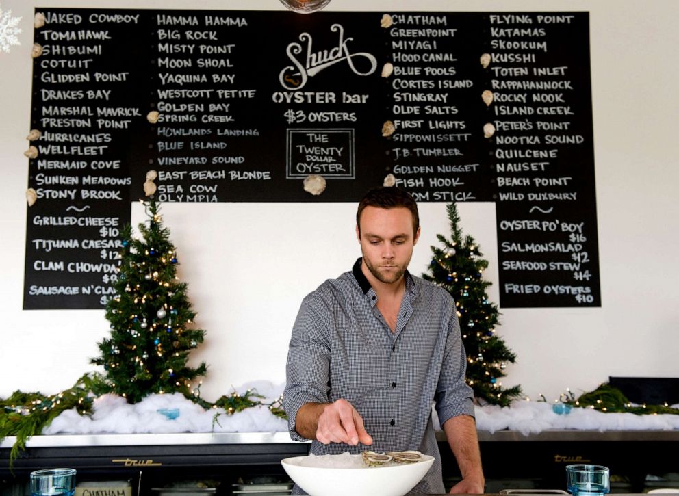 PHOTO: Kyle Rucker, lead shucker and manager, at Shuck Oyster Bar, prepares half-dozen oysters on ice.