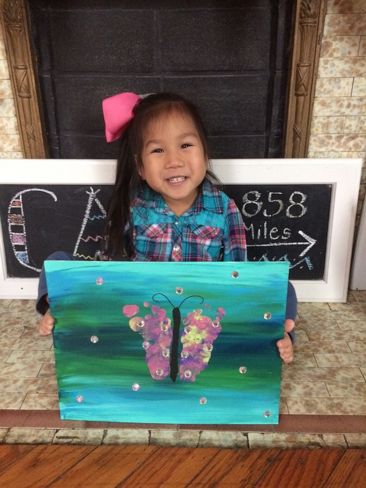 PHOTO: Four-year-old Minh Best holds up a painting of a butterfly that she created.