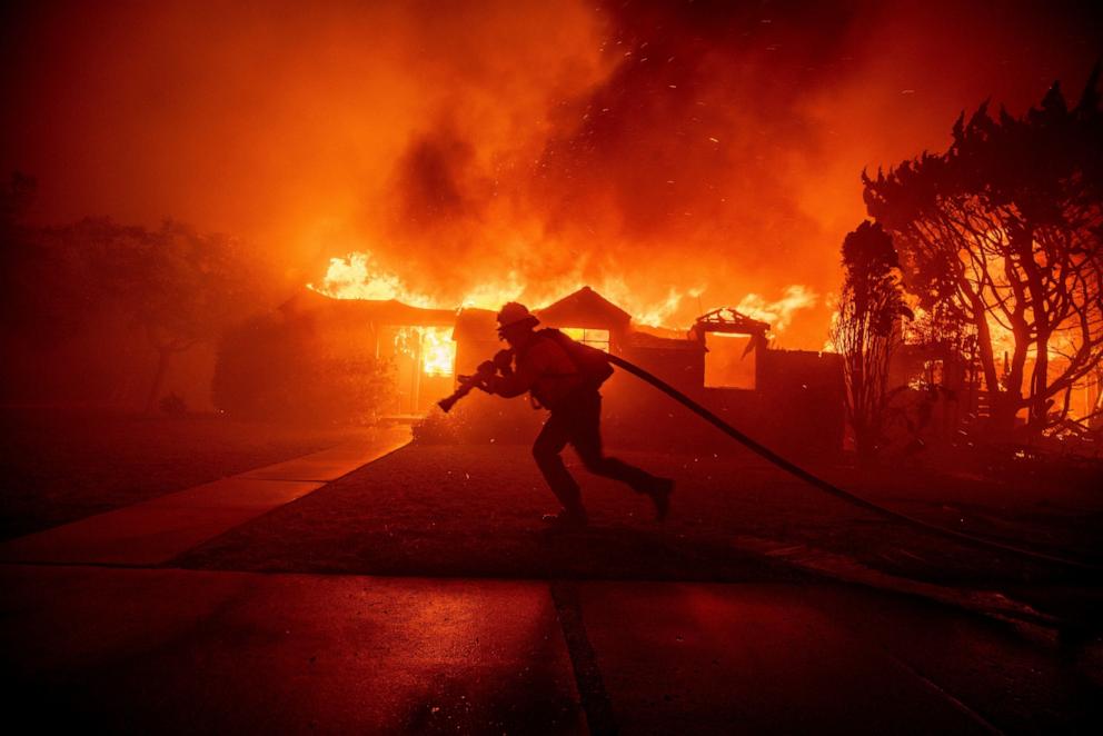 PHOTO: A firefighter battles the Palisades Fire as it burns a structure in the Pacific Palisades neighborhood of Los Angeles, Jan. 7, 2025.