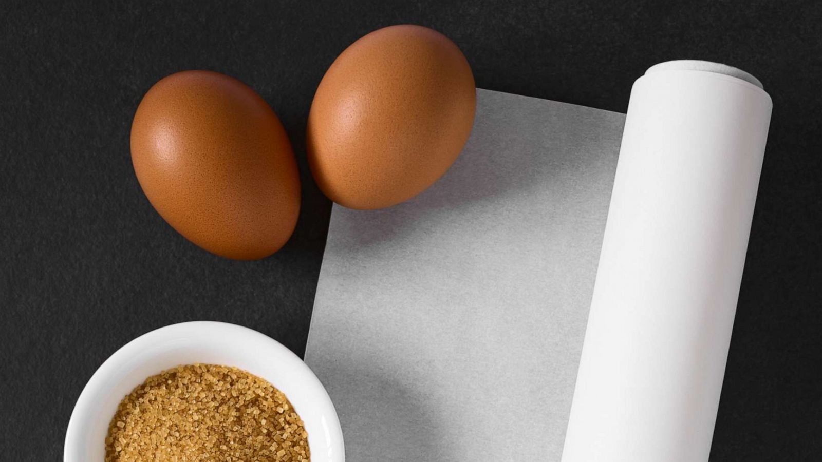 PHOTO: A roll of parchment paper sits on a counter with eggs and spices.