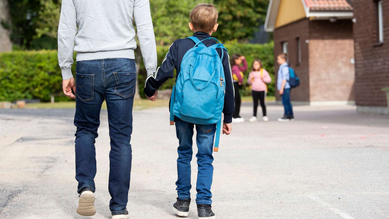 PHOTO: A dad walks his son to school.