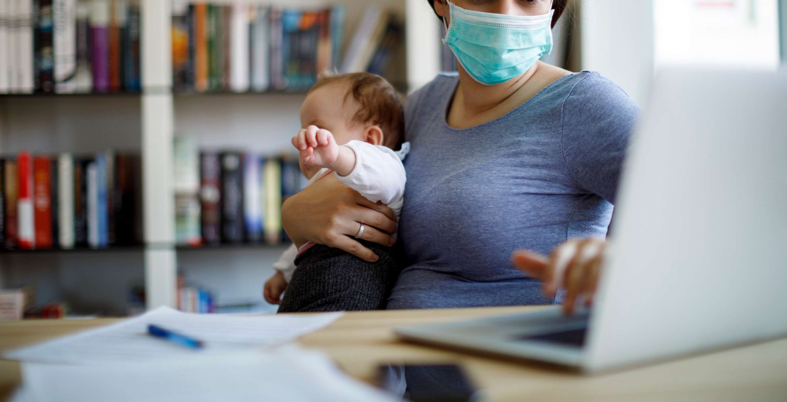 PHOTO: Mother with face protective mask working from home in an undated stock photo.
